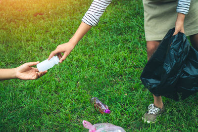 Low section of man holding hands on field