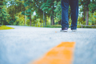 Low section of man standing on road