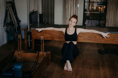 Full length portrait of woman exercising at gym