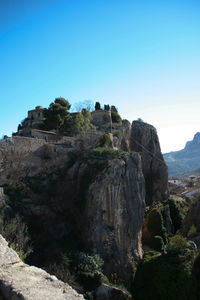 Rock formations on mountain against blue sky