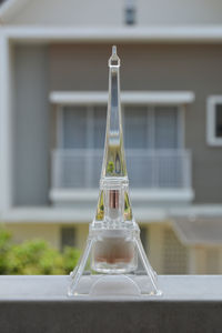 Close-up of glass bottle on table against building