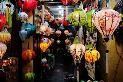 Illuminated lanterns hanging for sale at market stall