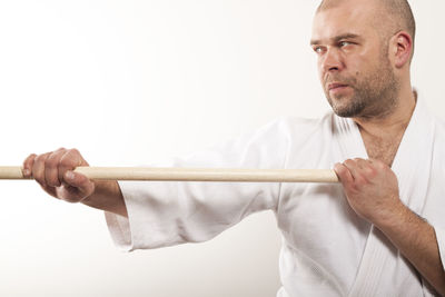 Portrait of man holding camera over white background