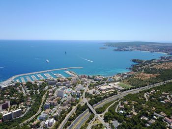 High angle view of road by sea against clear sky