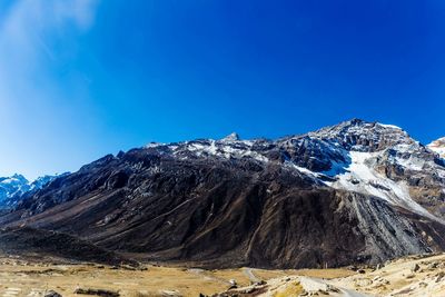 Scenic view of snowcapped mountains against clear blue sky