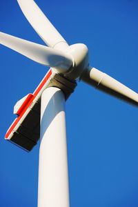 Low angle view of windmill against blue sky