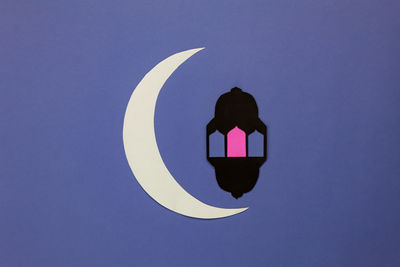 Paper moon with lantern on purple background