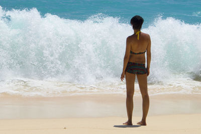 Rear view of woman standing on beach