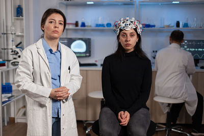 Portrait of female friends standing in laboratory