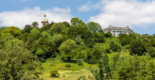 Trees by historic building against sky