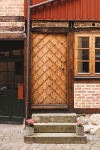 Entrance to and old building. reinforced wooden door, with some decorative flower pots on the stairs 