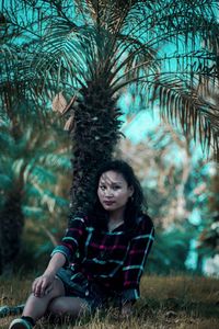 Portrait of young woman sitting in park