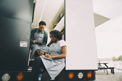 Female owner with assistant in food truck