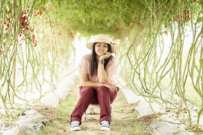 Young man looking away while sitting on land