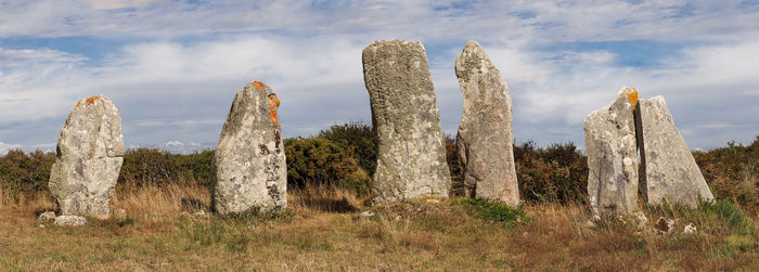 Panoramic shot of rocks on field against sky