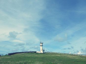 Lighthouse amidst buildings against sky