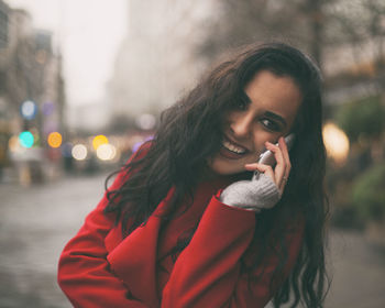 Young woman talking on mobile phone in city