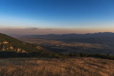 Scenic view of field against clear sky during sunset