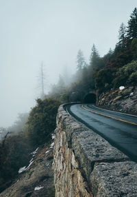 Road amidst trees against sky