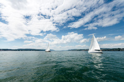 Sailboat sailing on sea against sky