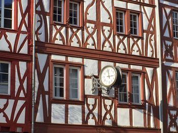 Low angle view of clock on glass window of building