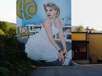 Portrait of young woman standing against built structure