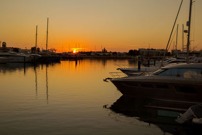 Sailboats in sea at sunset