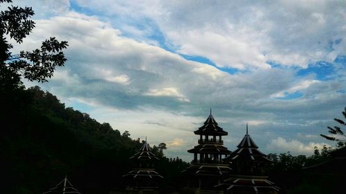 Silhouette of building and trees against sky