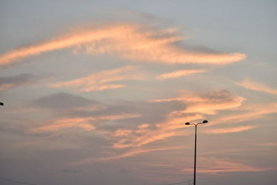 Low angle view of street light against dramatic sky