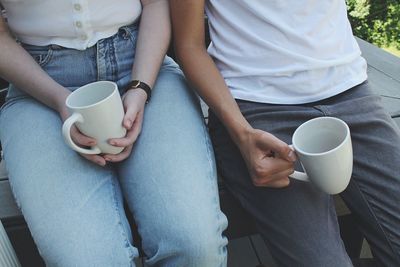 Low section of man and woman drinking coffee