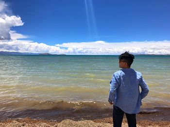 Man standing on beach against sky