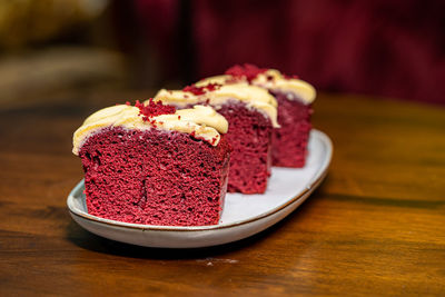 Slices of red velvet cake in a plate on a wooden table