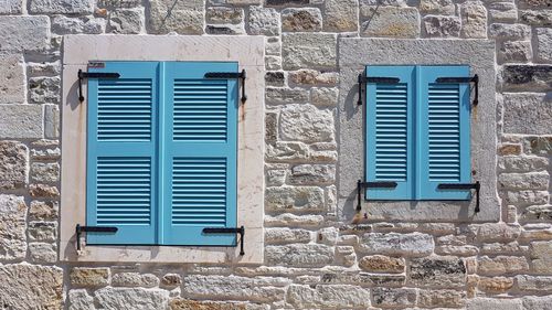 Closed window shutters on stone building