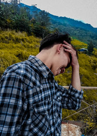 Side view of young man looking away on land