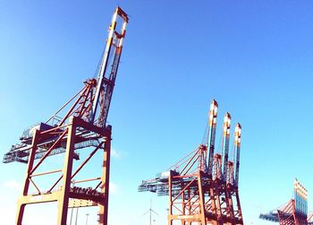 Low angle view of crane at harbor against clear sky