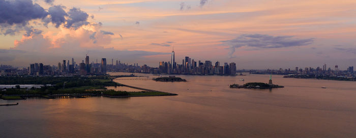 Scenic view of sea and buildings against sky during sunset