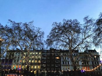 Low angle view of trees and buildings against sky