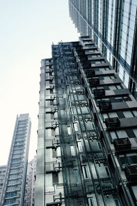 Directly below shot of modern buildings against clear sky