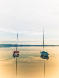 Sailboat moored on sea against sky