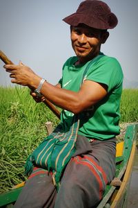 Young man smiling while sitting on field