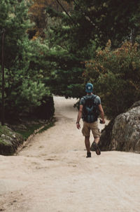 Rear view of man walking on footpath