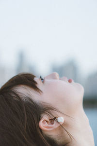 Close-up portrait of woman with hand on hair