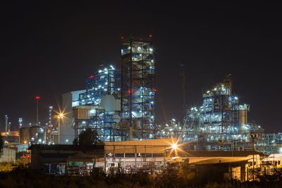 Illuminated buildings in city against sky at night