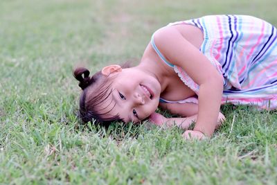 Portrait of woman lying on grassy field