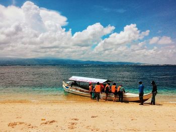 Panoramic view of people on beach against sky