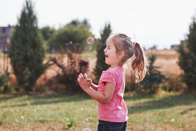 Girl playing with bubble on field