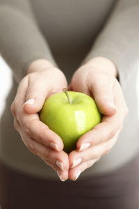 Cropped hand of woman holding apple