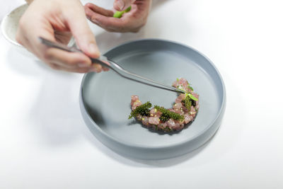 The chef is preparing food on the plate