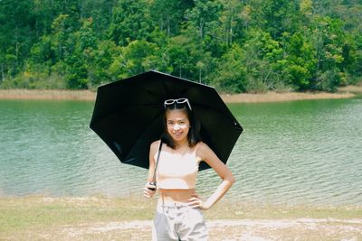 Portrait of smiling young woman standing on water