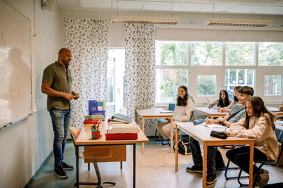 Male professor teaching to student in classroom